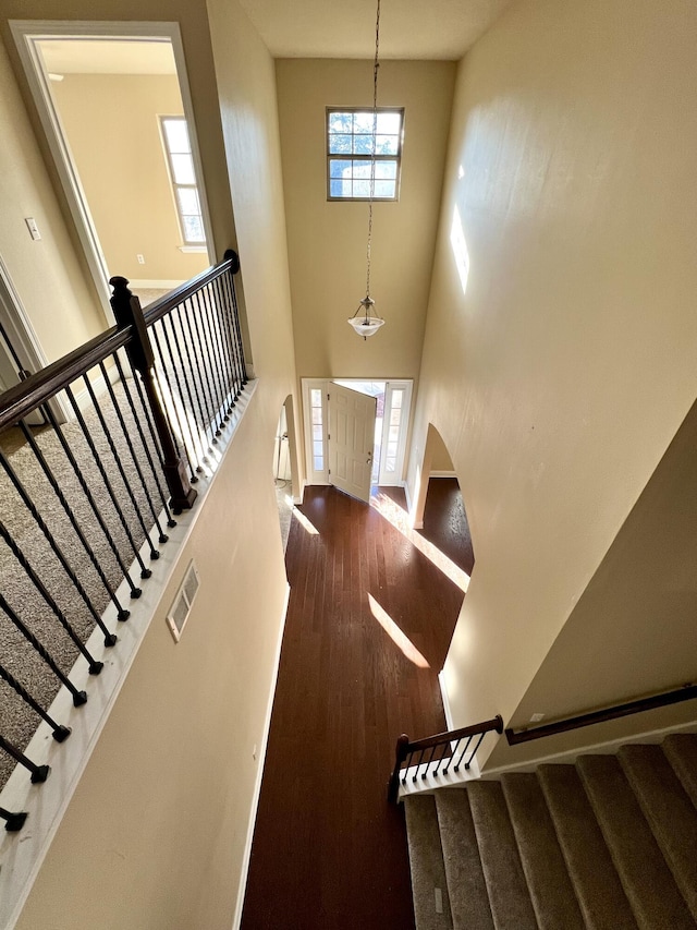 foyer entrance with a towering ceiling and hardwood / wood-style floors