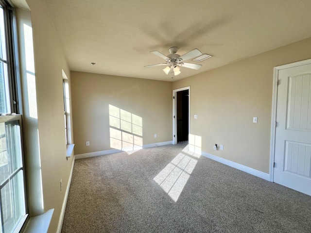 carpeted spare room with ceiling fan