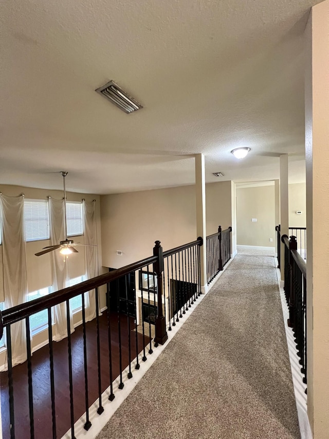 hall with plenty of natural light and a textured ceiling