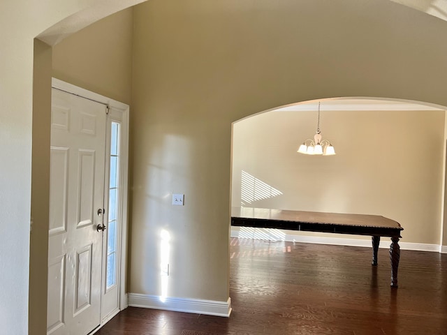 foyer entrance with a notable chandelier and dark hardwood / wood-style flooring