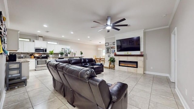 living room with ceiling fan, light tile patterned floors, and crown molding