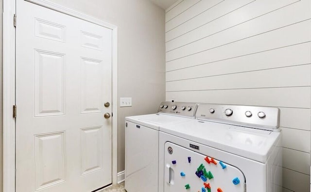 washroom with wood walls and washing machine and dryer