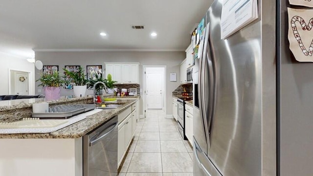 kitchen featuring sink, stainless steel appliances, light tile patterned floors, white cabinets, and ornamental molding