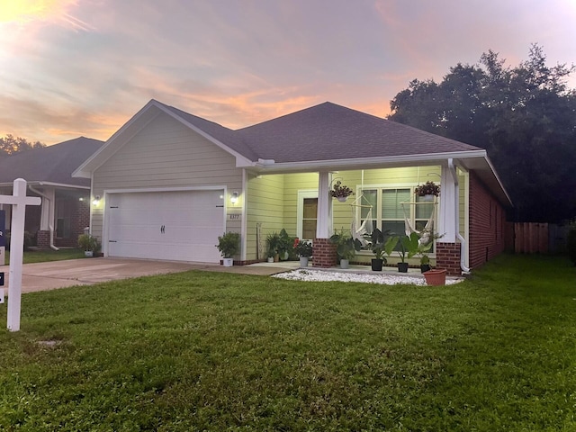 view of front facade featuring a porch, a garage, and a lawn