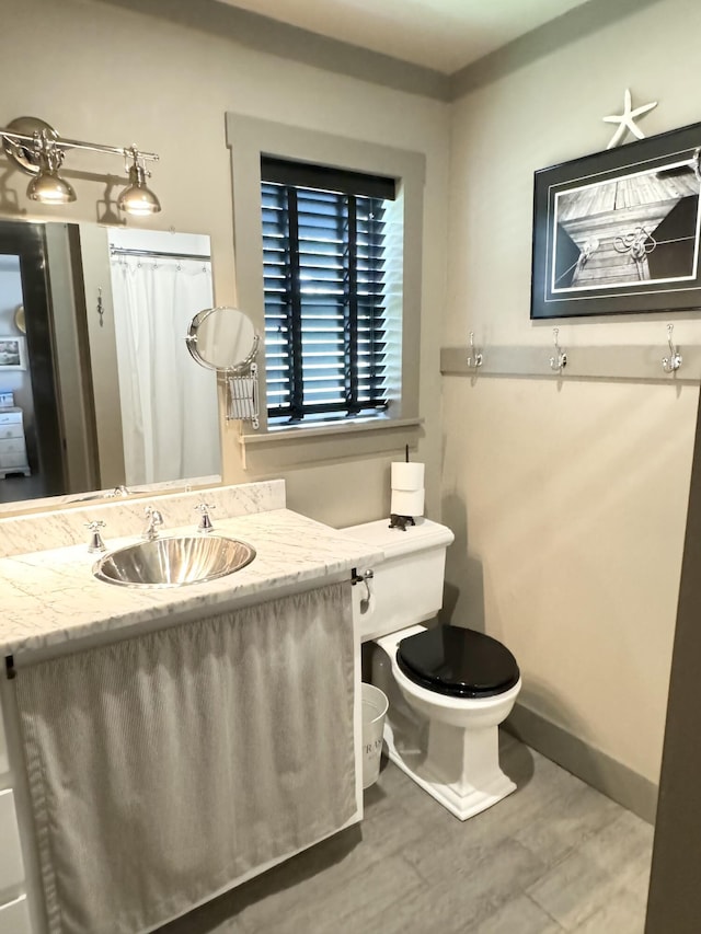 bathroom featuring toilet, vanity, and hardwood / wood-style flooring