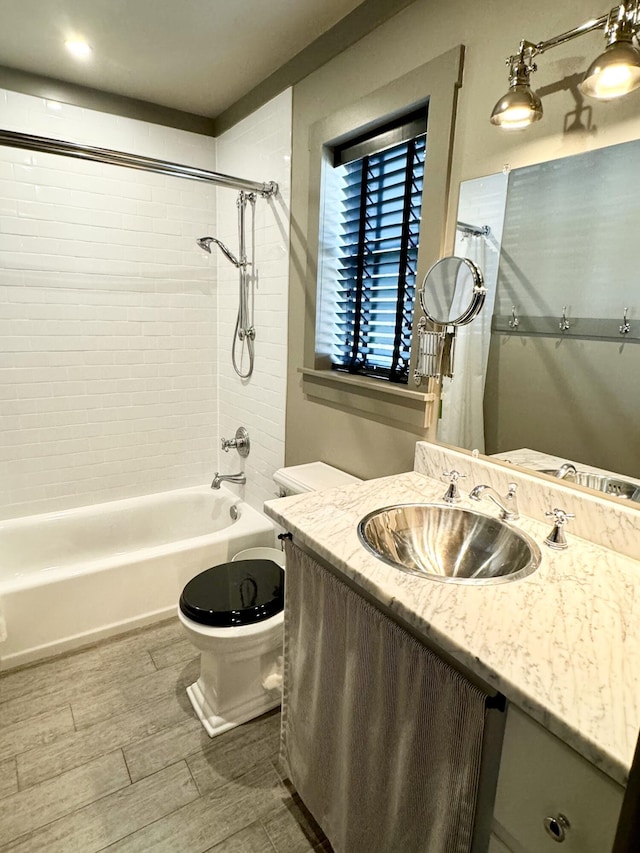 full bathroom with vanity, tiled shower / bath combo, and toilet