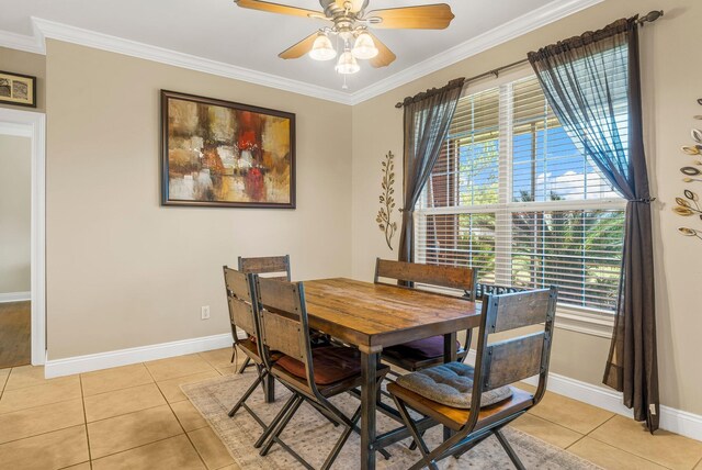 tiled dining area featuring crown molding and ceiling fan