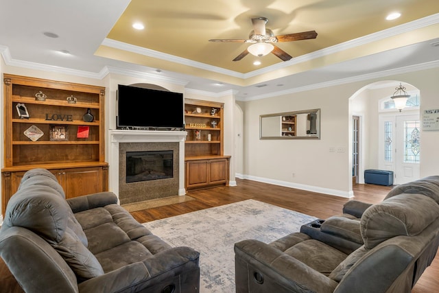 living room with a raised ceiling, crown molding, ceiling fan, and hardwood / wood-style flooring