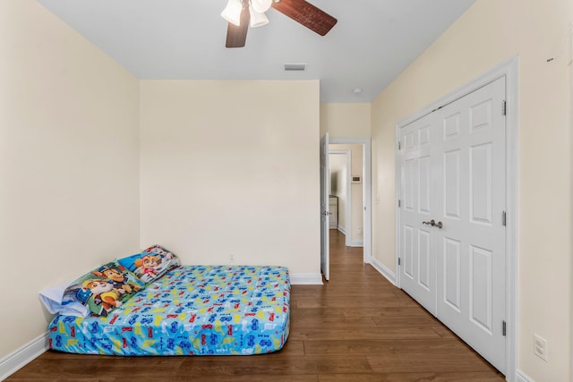 bedroom with a closet, ceiling fan, and dark wood-type flooring