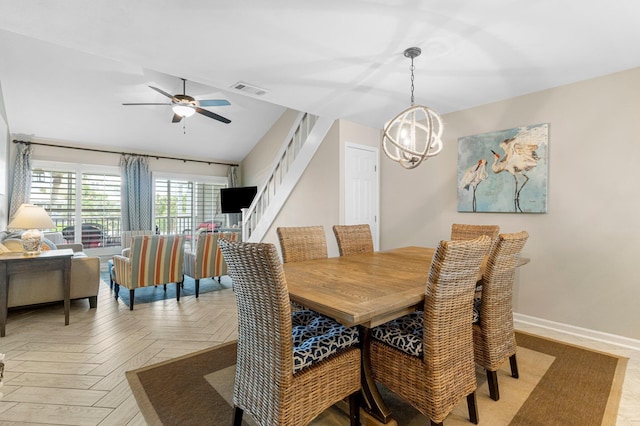 dining area featuring light parquet floors and ceiling fan with notable chandelier