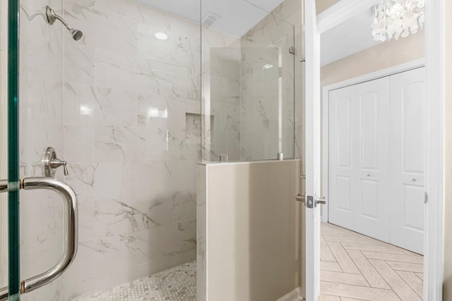 bathroom with an enclosed shower and parquet flooring