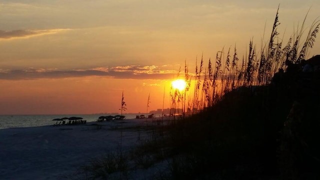 nature at dusk featuring a water view and a view of the beach