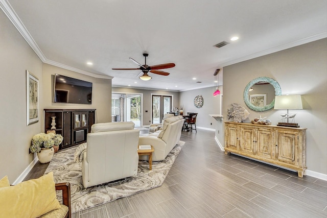 living room with ceiling fan and ornamental molding