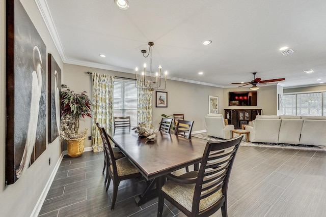 dining room with a wealth of natural light, crown molding, and ceiling fan with notable chandelier