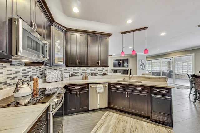 kitchen featuring dark brown cabinetry, sink, hanging light fixtures, stainless steel appliances, and decorative backsplash