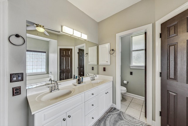 bathroom with vanity, tile patterned floors, ceiling fan, toilet, and a tub