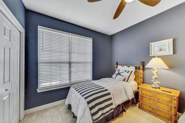 carpeted bedroom with ceiling fan and a closet