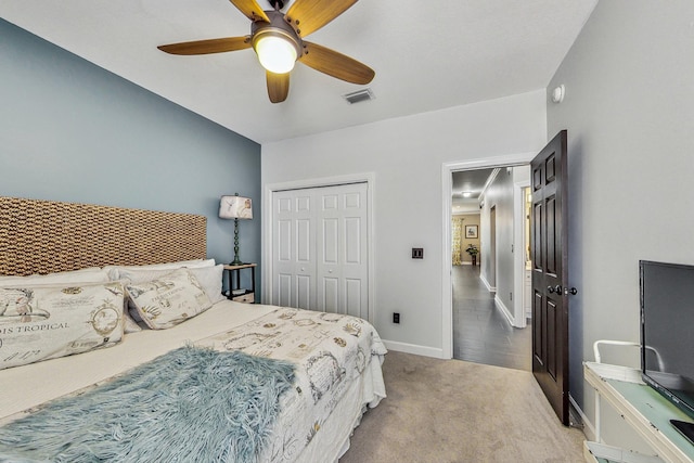 bedroom with ceiling fan, light carpet, and a closet