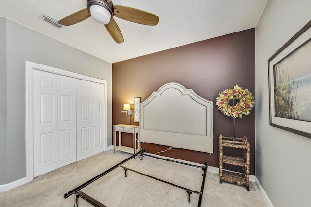 carpeted bedroom featuring ceiling fan and a closet