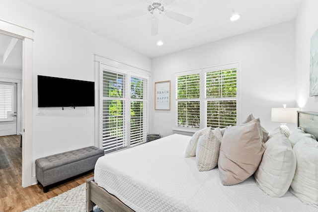 bedroom with multiple windows, hardwood / wood-style floors, and ceiling fan