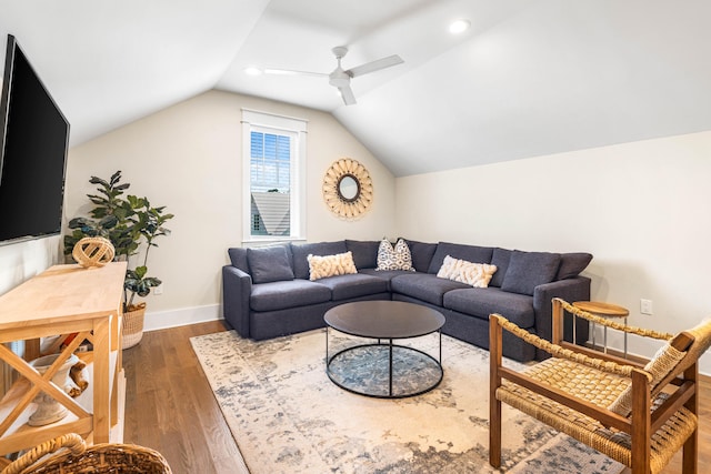 living room featuring ceiling fan, dark wood-type flooring, and vaulted ceiling