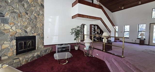 carpeted living room featuring wood ceiling, a fireplace, and high vaulted ceiling