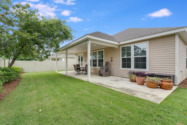 rear view of property with a lawn and a patio