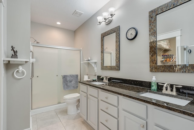 bathroom featuring tile patterned floors, vanity, toilet, and an enclosed shower