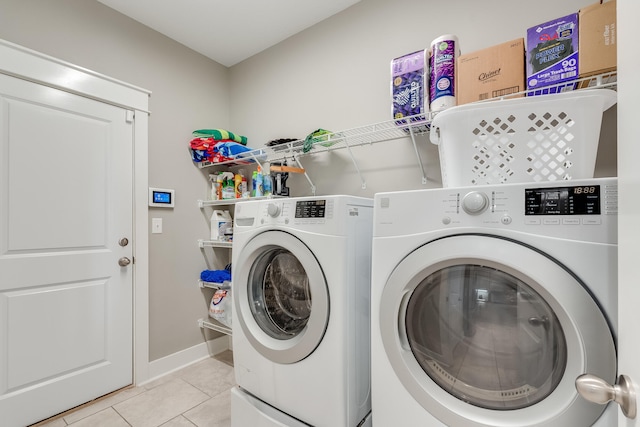 laundry area with washer and dryer and light tile patterned floors