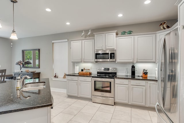 kitchen with white cabinets, decorative light fixtures, sink, and appliances with stainless steel finishes