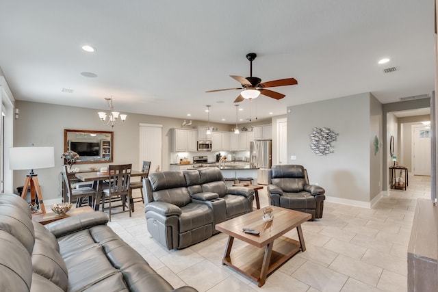 tiled living room with ceiling fan with notable chandelier