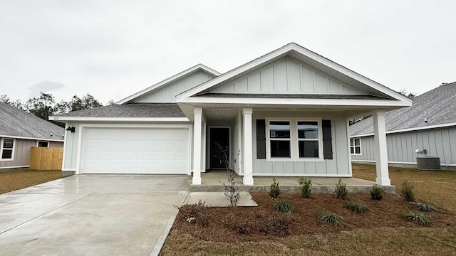 view of front of property featuring a garage and central AC