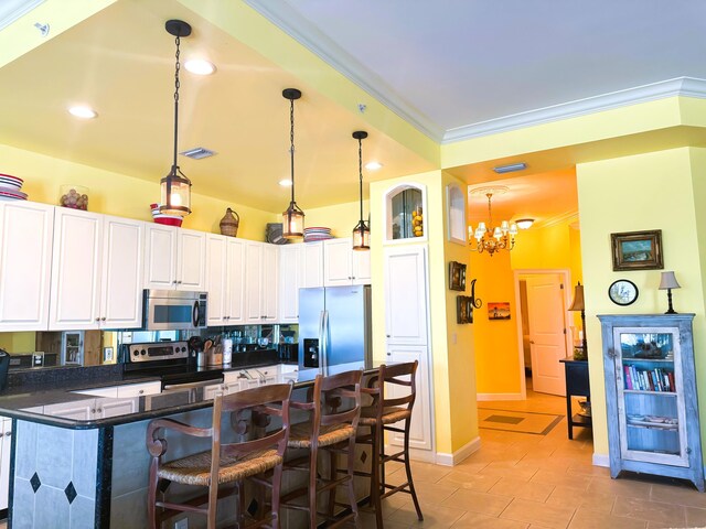 kitchen featuring pendant lighting, backsplash, appliances with stainless steel finishes, a kitchen bar, and white cabinets