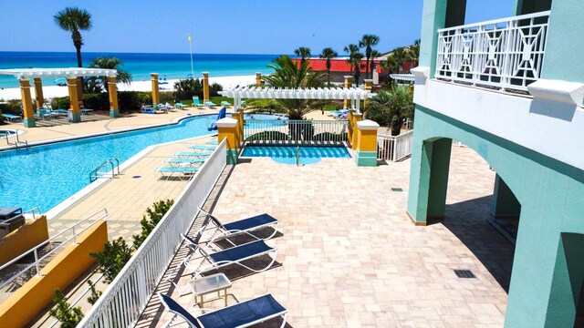 view of swimming pool featuring a water view and a patio area