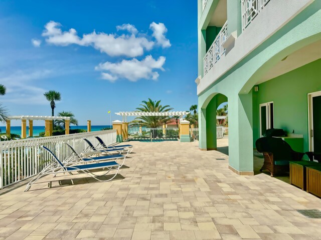 view of patio featuring a balcony, a pergola, and a water view