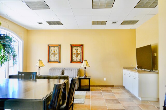 home office featuring light tile patterned flooring and a drop ceiling