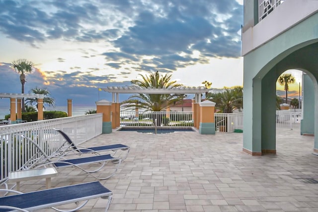 patio terrace at dusk with a pergola and fence