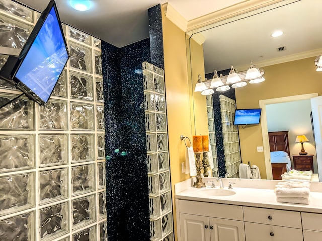 bathroom with crown molding, vanity, and walk in shower