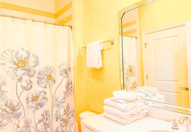 bathroom with curtained shower, toilet, and vanity