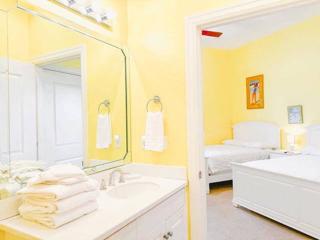 ensuite bathroom featuring connected bathroom, vanity, and tile patterned flooring