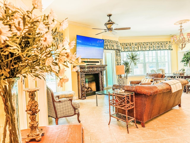 living room with tile patterned flooring, ornamental molding, a fireplace, and ceiling fan with notable chandelier