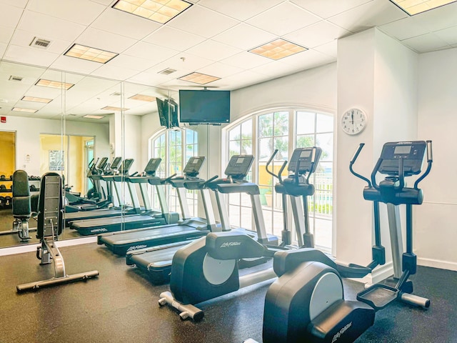 gym with visible vents, baseboards, and a drop ceiling