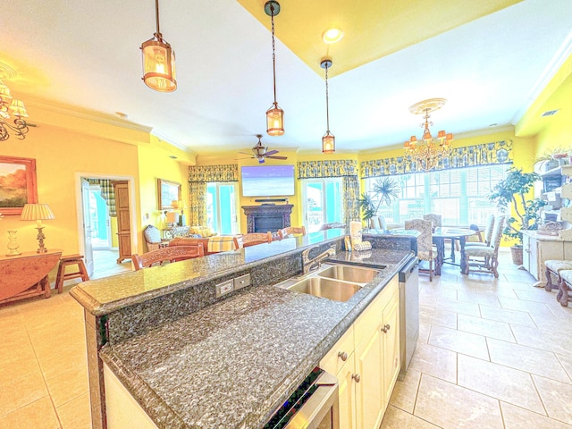 kitchen with a center island with sink, a sink, open floor plan, light tile patterned flooring, and crown molding