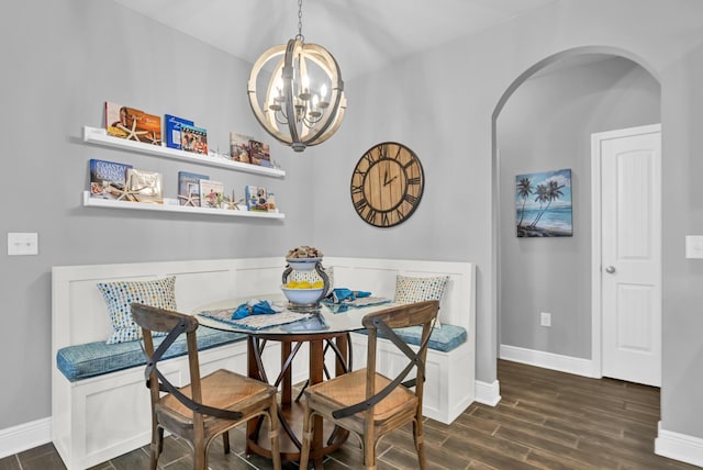 dining space with dark hardwood / wood-style floors and a notable chandelier