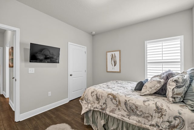 bedroom with dark hardwood / wood-style floors