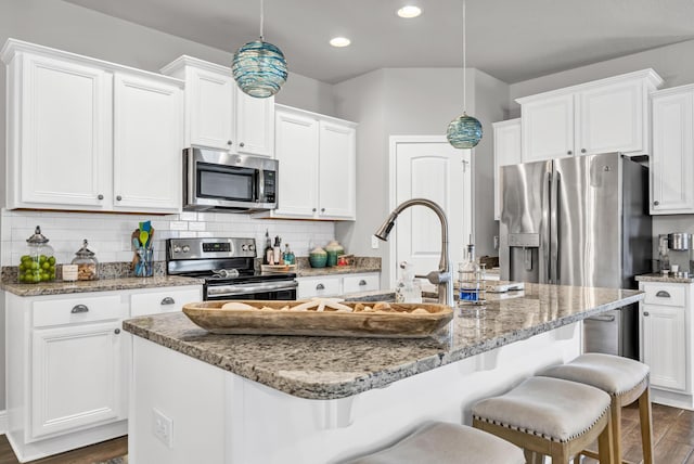 kitchen with white cabinets, dark wood-type flooring, an island with sink, and stainless steel appliances