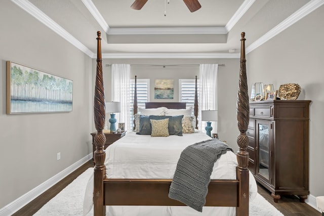 bedroom with a tray ceiling, ceiling fan, and dark wood-type flooring