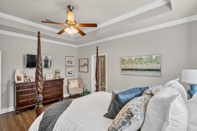 bedroom featuring dark hardwood / wood-style flooring, a tray ceiling, ceiling fan, and ornamental molding