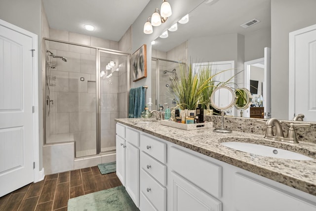 bathroom with a shower with door and vanity