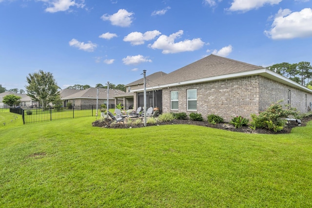 rear view of house with a sunroom and a lawn